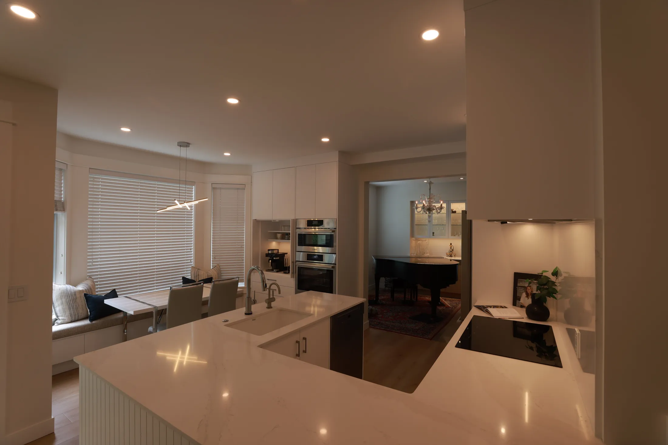 Breakfast nook bay-window seating opens toward the wall ovens and dining room beyond.