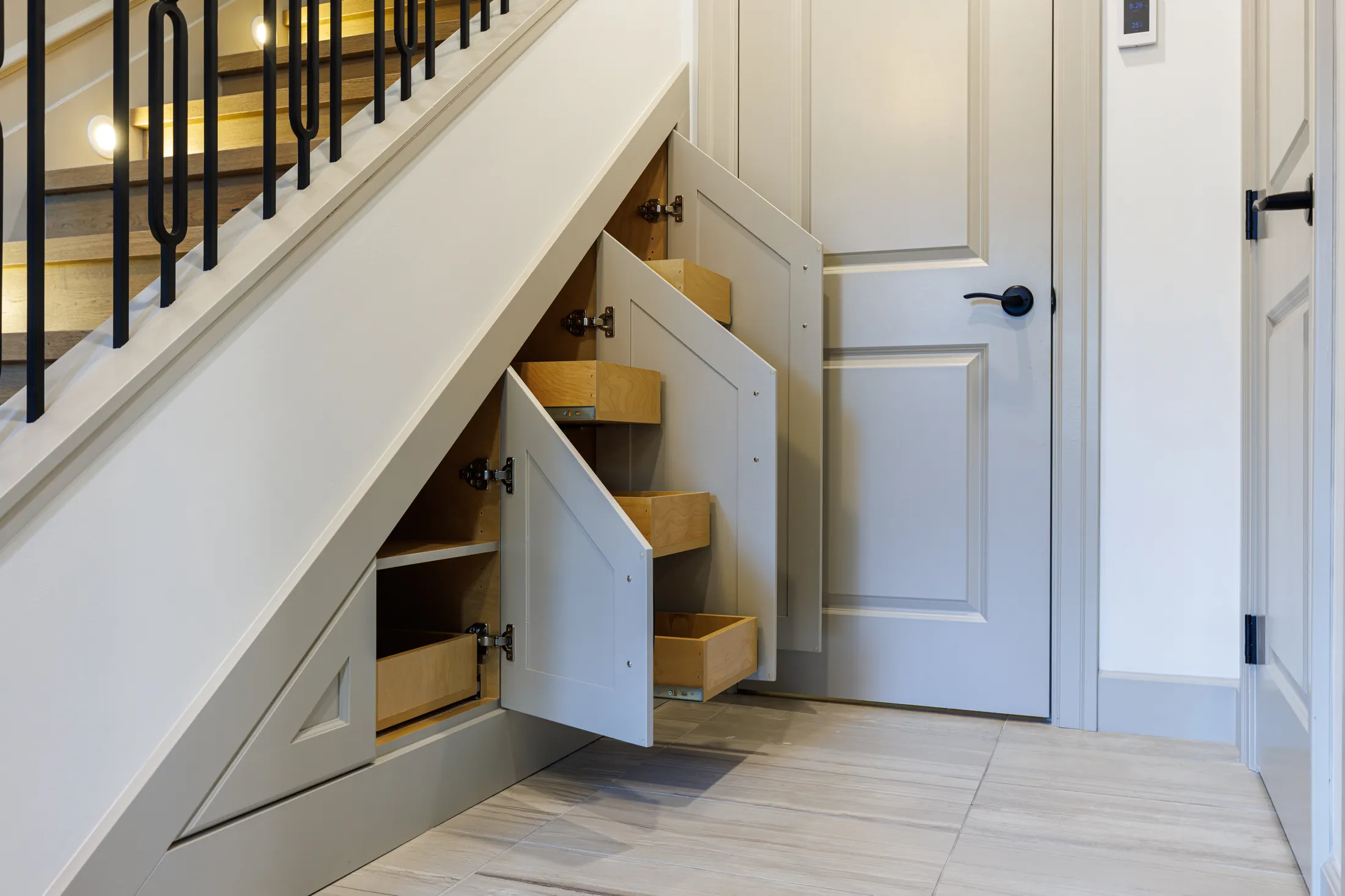 Under-stair storage with angled pull-out drawers built into the triangular space beneath the staircase.