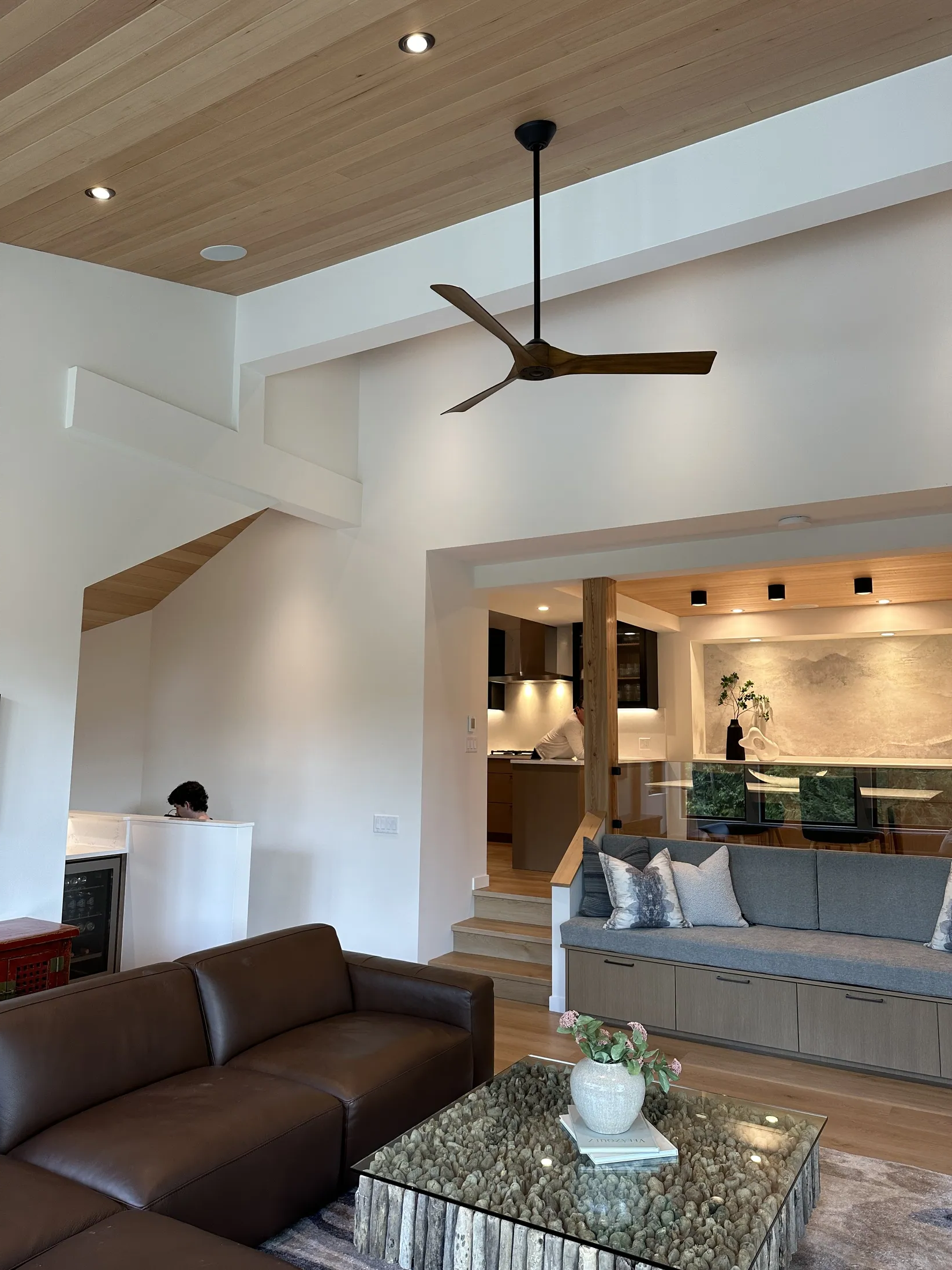 Great room seen from the entry loft, leather sectional in foreground, sunken kitchen and dining below.